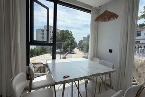 A room with a large window, a dining table, and chairs. - Wanghai Hotel (Fuding)
