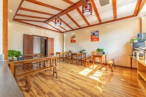 A room with wooden flooring, a kitchen area, and a dining space with tables and chairs. - GreenTree Alliance Hotel (Kunming Chuanjin Road Subway Station) (Kunming)