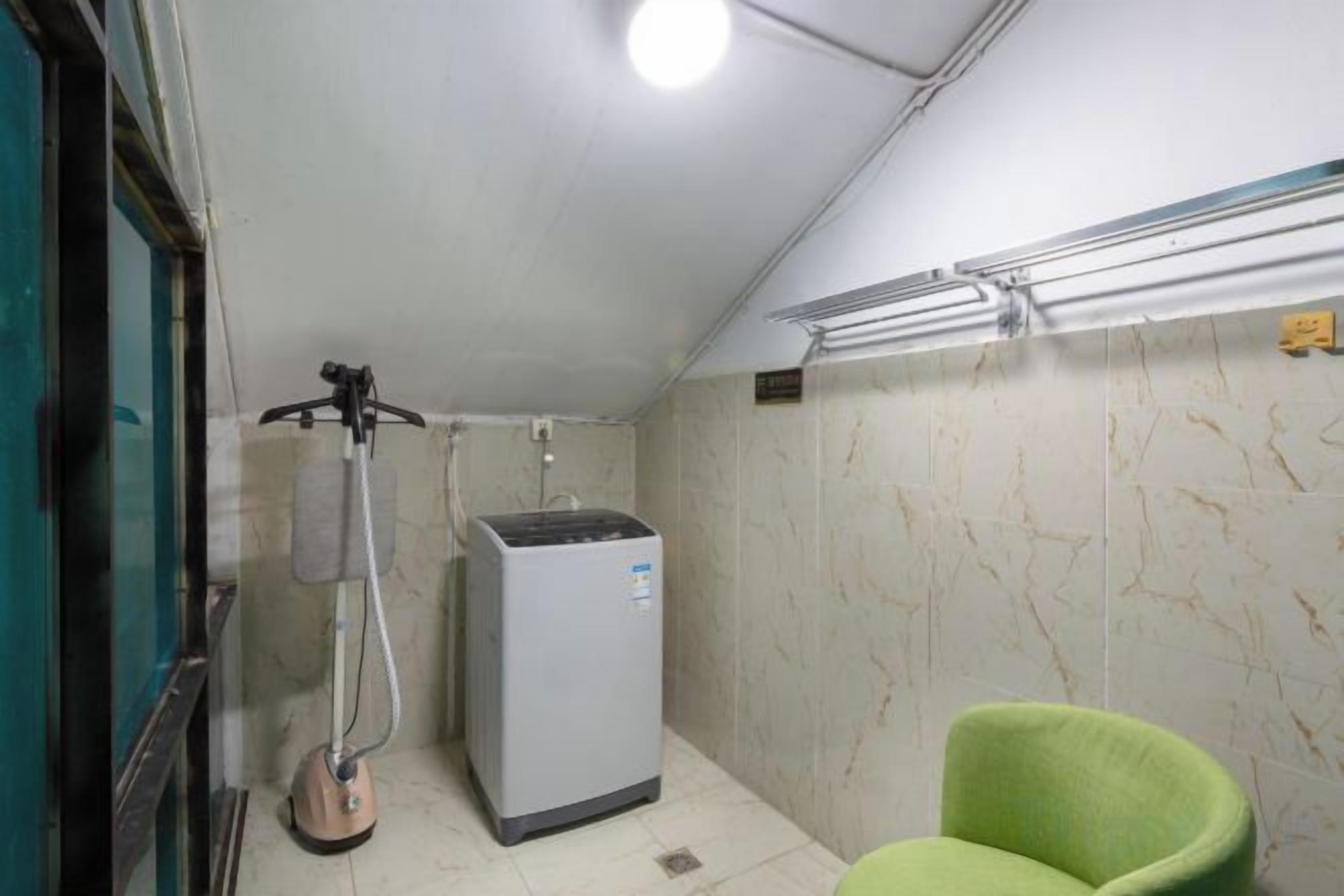 A small room with a heater, a chair, and a wall-mounted shelf.