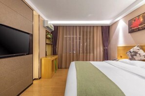 A hotel room with a large bed, a flat-screen TV, a small desk, and a bookshelf. - GreenTree Alliance Hotel (Kunming Chuanjin Road Subway Station) (Kunming)