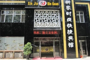 Un edificio con fachada negra y detalles amarillos, que presenta un gran letrero con caracteres chinos y un logotipo.