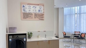Une salle de bain moderne équipée d’un lave-linge, d’un lavabo et d’un tableau d’affichage contenant des instructions.