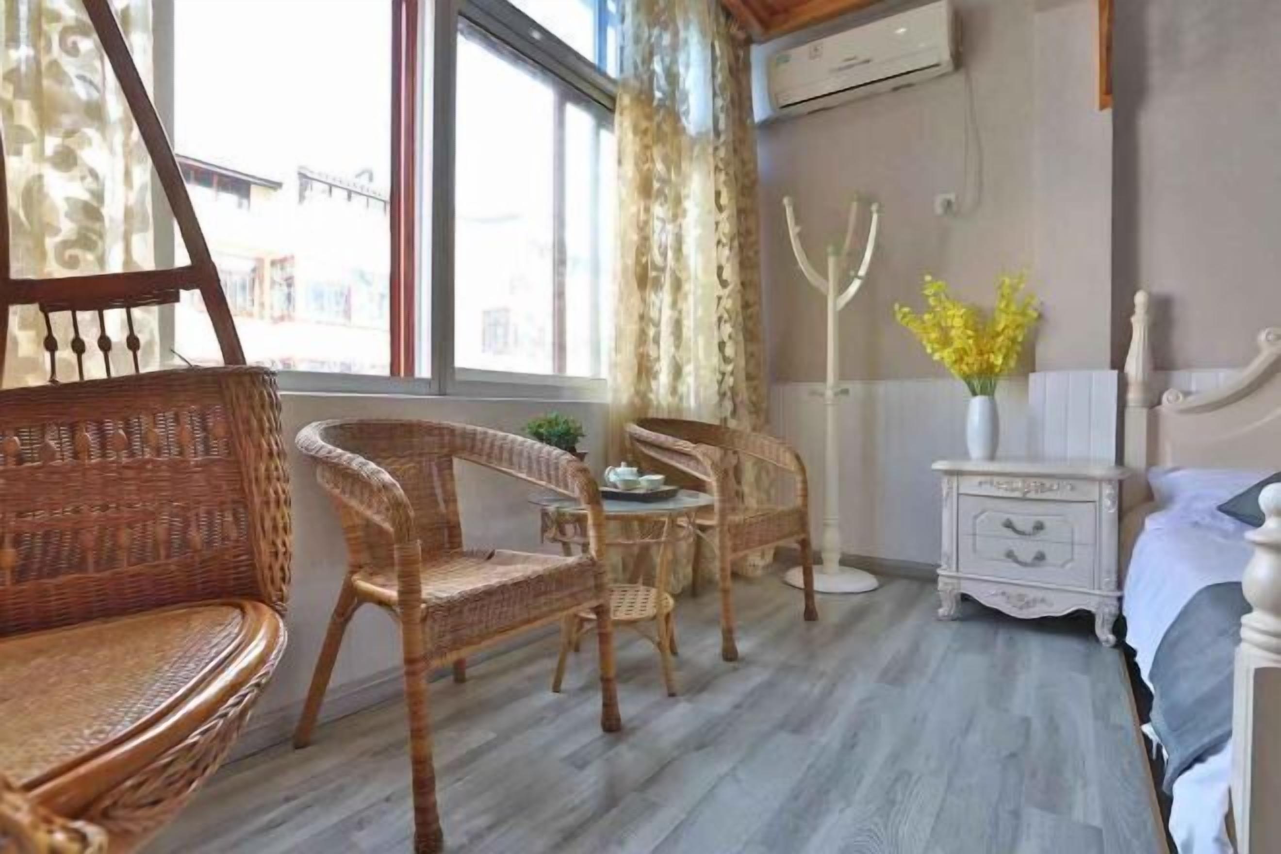 Ein Zimmer mit Korbmöbeln, einem weißen Schminktisch und einem Bett.
