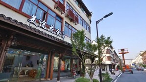A building with a sign that reads "美逸旅舍" (Meiyi Travel Inn). - Meitu Huashe Guesthouse (Tongxiang)