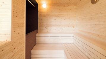A wooden sauna with a brick wall, a wooden bench, and a round wall clock.