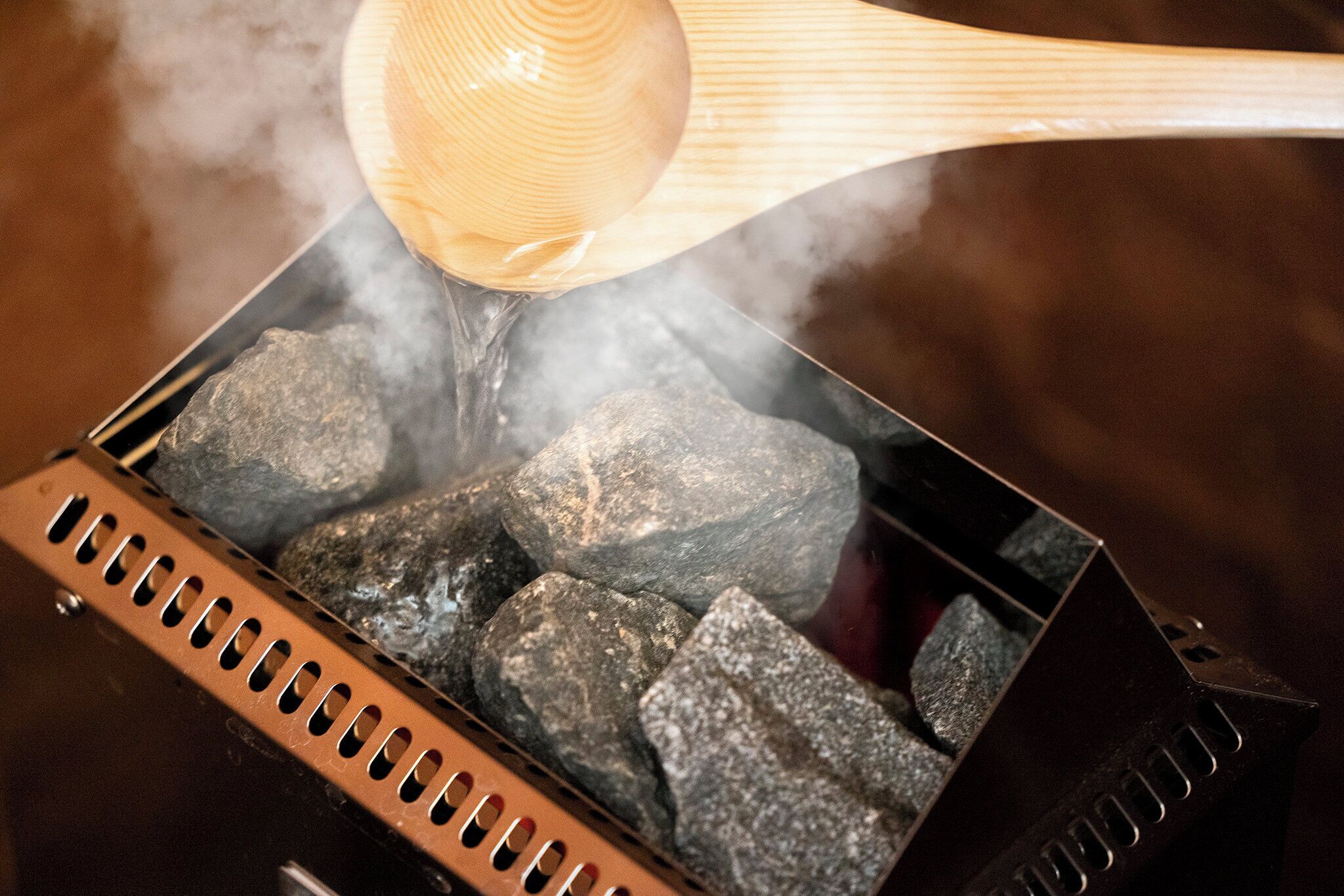 Ein Grill mit Holzkohle und einem Holzlöffel.