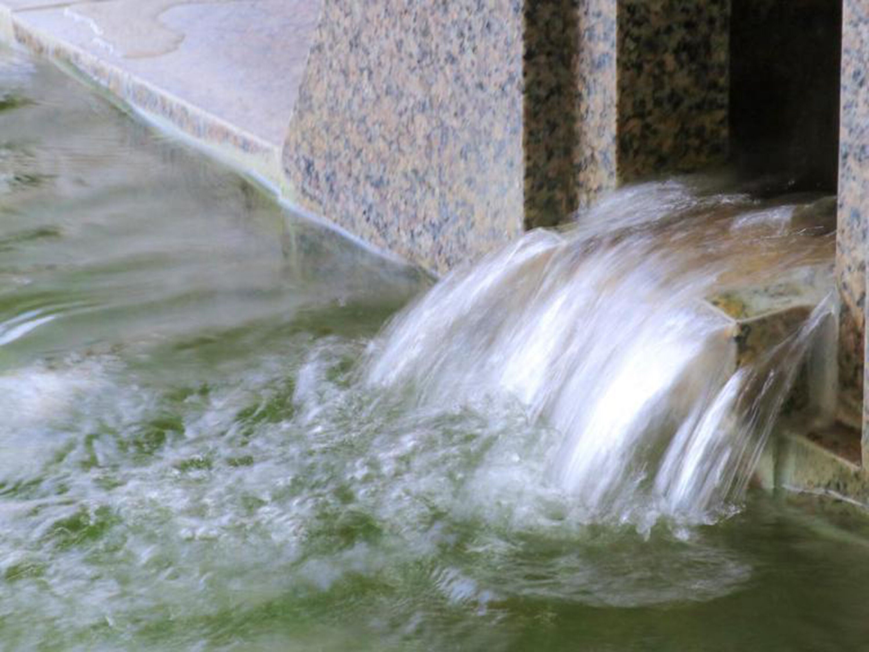 A water feature with a cascading flow over a stone structure.