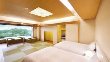 A modern hotel room with two beds, a desk, and a view of the outdoors.