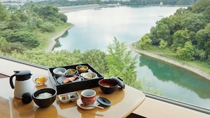 A table with a meal set and a view of a river. - Kikusuitei (Higashiyamato)