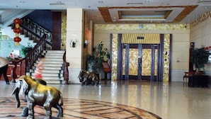 A lobby with a marble floor, a staircase, and a reception area with a decorative elephant statue. - Fushun Tiantian Hotel (Mudanjiang High-speed Railway Wanda Branch) (Mudanjiang)