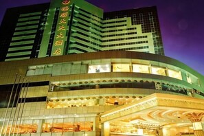 A hotel with a modern facade, multiple floors, and a prominent entrance. - Fushun Tiantian Hotel (Mudanjiang High-speed Railway Wanda Branch) (Mudanjiang)