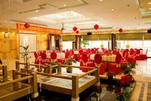 A banquet hall with round tables, red chairs, and a central aisle. - Fushun Tiantian Hotel (Mudanjiang High-speed Railway Wanda Branch) (Mudanjiang)