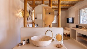 A bathroom with a large, round, marble sink, a wooden ceiling, and a television mounted on the wall. - Bohemian Kea Beach Club Resort (Kea)