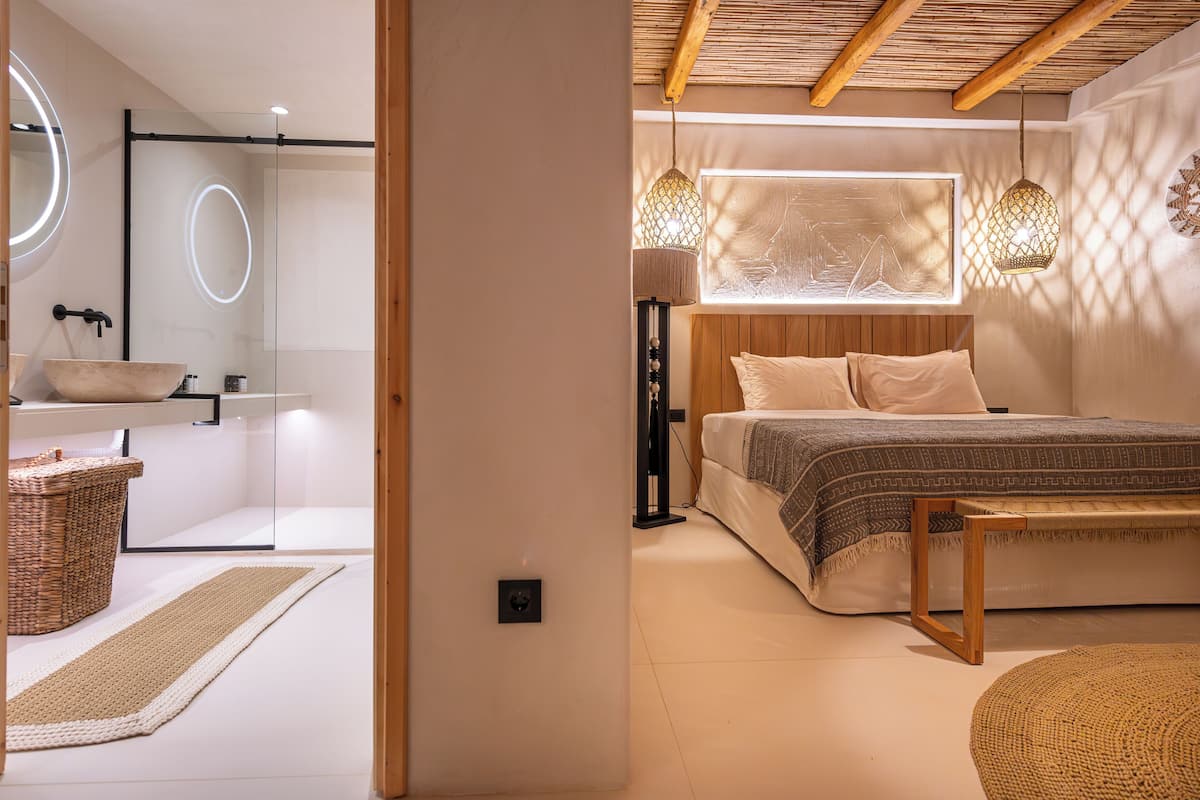 A modern bedroom with a large bed, bedside lamps, and a wooden headboard.