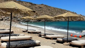 A beach with sun loungers and thatched umbrellas. - Bohemian Kea Beach Club Resort (Kea)