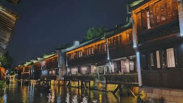 A traditional building with multiple levels, a wooden bridge, and a waterway.