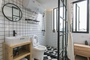 A bathroom with a white sink, toilet, and a glass shower enclosure. - Those Years · Joyful Lan · Qijing Garden Homestay (West Gate Scenic Spot) (Tongxiang)