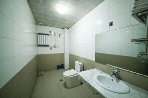 A bathroom with a toilet, sink, and shower.