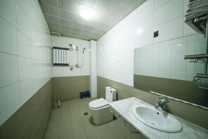 A bathroom with a toilet, sink, shower, and towel rack. - WEI LONG HOTEL (Wuwei)