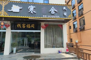 A hotel entrance with a glass door, a telephone number, and a sign with Chinese characters. - Lushan Hanshe Homestay (Donglin Buddha) (Lushan City)