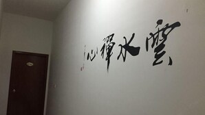 Un mur orné de grands caractères chinois noirs.