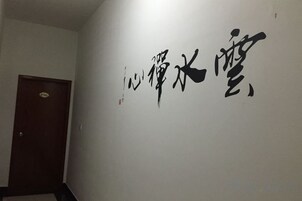Un pasillo con una puerta y una pared con caligrafía negra de gran tamaño.