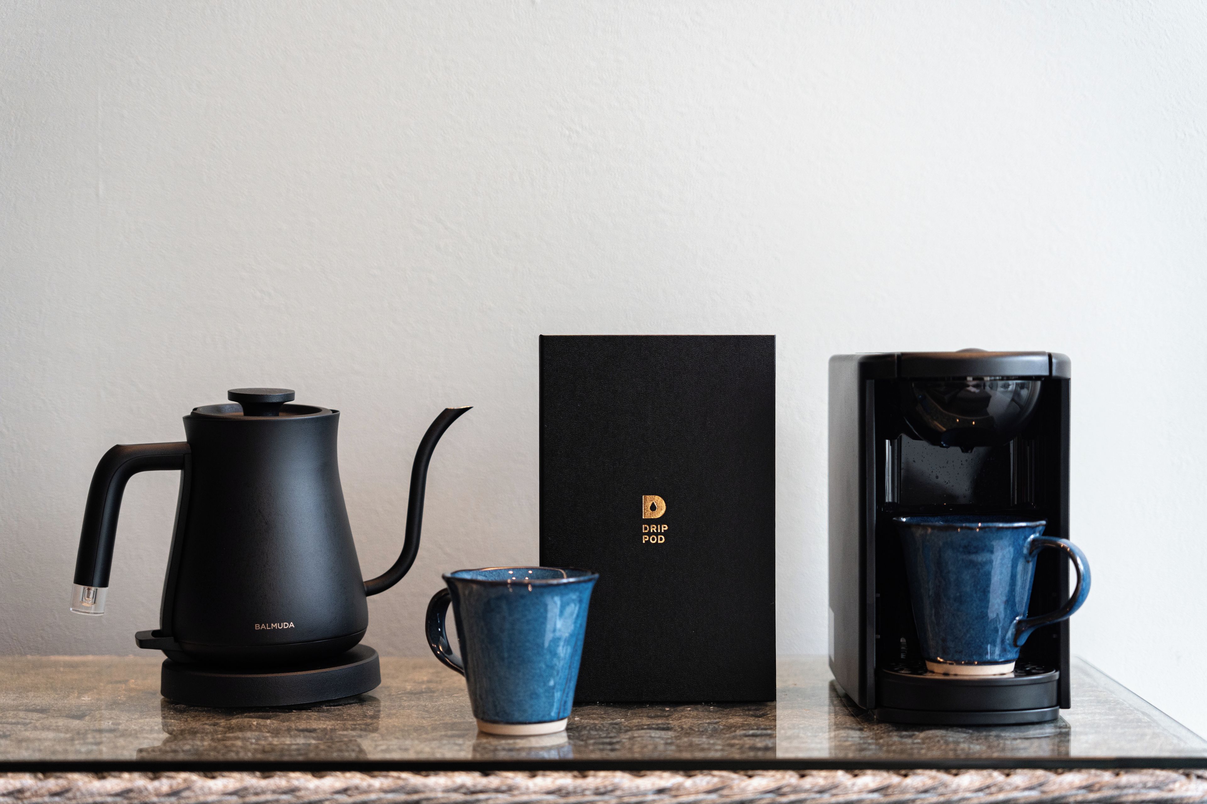 A coffee maker, a mug, and a box on a countertop.