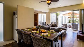 A dining area with a wooden table, wicker chairs, and a ceiling fan.