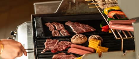 A grill with various meats and vegetables being cooked.