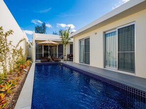 A modern pool area with a clear blue pool, lounge chairs, and a covered seating area. - Pool Villa Yagaji Island by Coldio Premium (Nago)