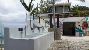 Ein moderner Außen-Spa-Bereich mit mehreren Badewannen und einer Treppe zu einer erhöhten Ebene.