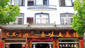 A traditional building with a signboard indicating a restaurant.