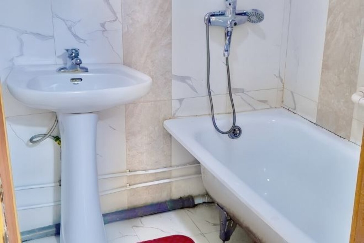 Une salle de bain avec un lavabo blanc, une baignoire et une douche.
