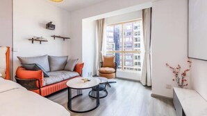 A modern living room with a sofa, a coffee table, and a window with curtains. - Caiyun Jiayuan (Nanping Street Old Street Kunming) (Kunming)