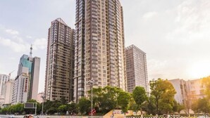 A high-rise building with multiple floors, surrounded by other tall buildings and trees. - Caiyun Jiayuan (Nanping Street Old Street Kunming) (Kunming)