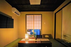A traditional Japanese room with tatami flooring, a shoji screen, and a low table with a lamp. - Kyoran Suigetsutei (Kyoto)