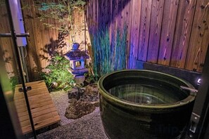 A wooden bench, a hot tub, and a decorative lantern in a garden setting. - Kyoran Suigetsutei (Kyoto)