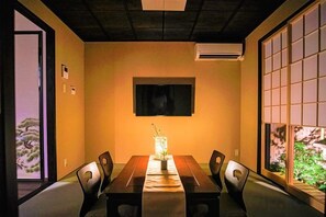 A conference room with a long table, chairs, a TV on the wall, and a view through a window. - Kyoran Suigetsutei (Kyoto)