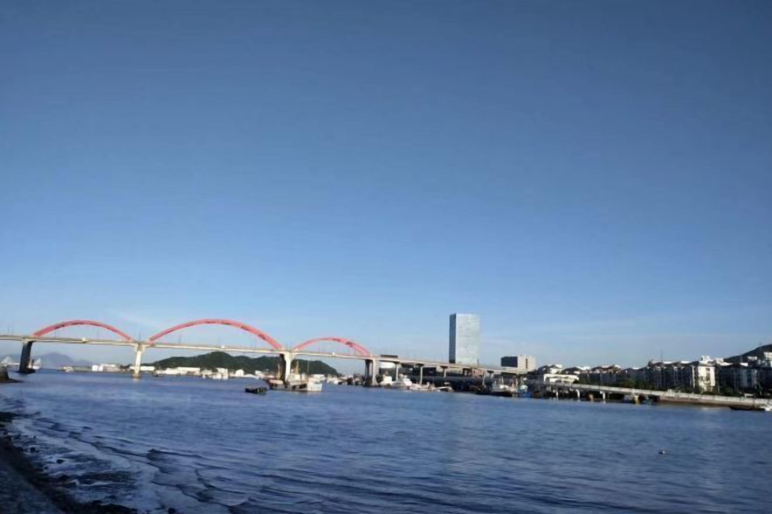 Vista al agua con un puente, barcos y edificios.