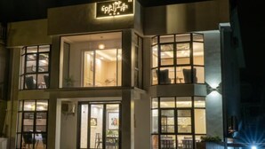 A modern building with a sign that reads "EPIC HOTEL". It features large windows and a well-lit interior. - Yin Xiang Jiang Nan Inn (Yixing)