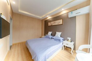 Un dormitorio moderno con cama, mesitas de noche, una silla y un aire acondicionado.