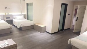 A hotel room with two beds, a bedside table, a nightstand, a small seating area, and a wardrobe. - Huilong Dasha Hotel (Chengde)