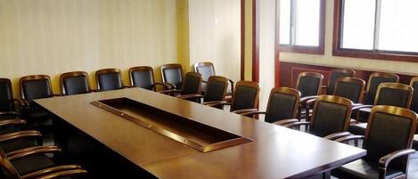 A conference room with a long table and chairs arranged around it.