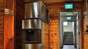 Un réfrigérateur en acier inoxydable situé au premier étage d’un bâtiment de style cabane en bois.