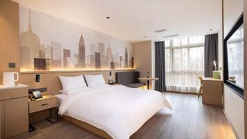 Habitación de hotel con una cama grande, mesitas de noche, un ventanal con cortinas y un mural con vista a la ciudad.