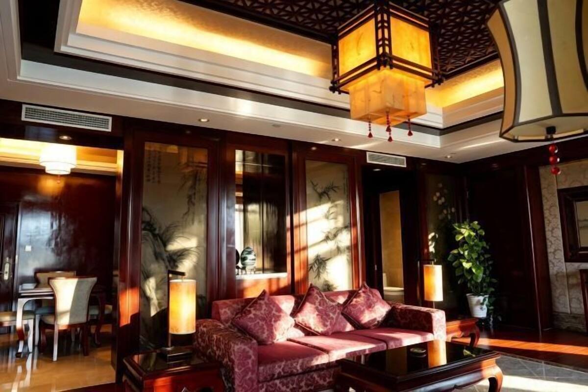 A lobby with a sofa, a table, and a hanging lantern.
