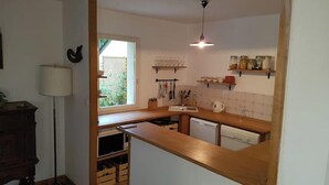 A compact kitchen with a wooden countertop, a sink, and a hanging light fixture. - Maison Sarzeau / Saint Gildas de Rhuys (Sarzeau)