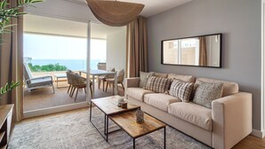 A modern living room with a sofa, coffee table, and a large window overlooking a balcony. - Luxury Premium Isea 1122 by Casasol (Torrox Costa)