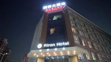 A hotel building with illuminated signage, multiple floors, and a prominent entrance.