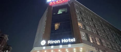 A hotel building with illuminated signage, multiple floors, and a prominent entrance.